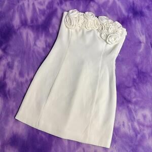 Meshki white strapless bodycon dress with rose detailing.